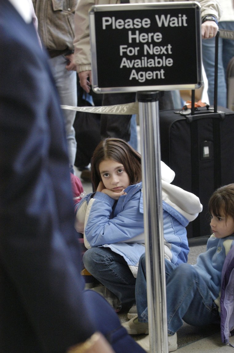 Nikki Cullifer, 10, of Philadelphia, Pa., waits patiently in line for the next available US Airways ticket agent so she can get a boarding pass for a flight to North Carolina.